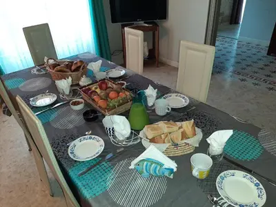 a table with a blue table cloth with food on it at le Mas d'Hubert in LʼIsle-sur-la-Sorgue