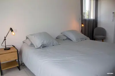 a bedroom with a white bed with two pillows at BASTIDE 9 in La Fare-les-Oliviers