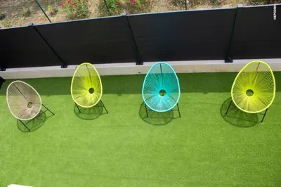 a group of three chairs sitting on the grass at BASTIDE 9 in La Fare-les-Oliviers