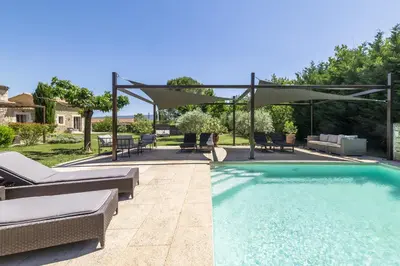 a swimming pool with a patio and an umbrella at Mas OREA in Gordes