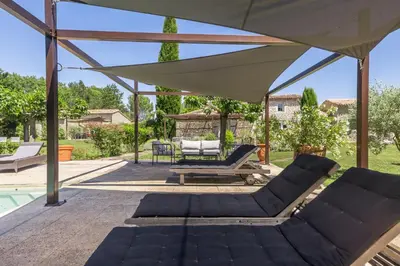 a gazebo with two lounge chairs and an umbrella at Mas OREA in Gordes