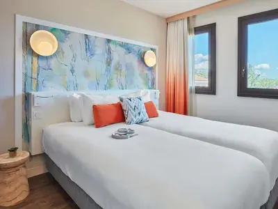 a room with a bed and a couch and a mirror at Aparthotel Adagio Aix-en-Provence Centre in Aix-en-Provence