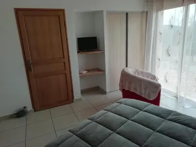 a bedroom with a bed and a chair and a window at LA MAGUETTE in Sault-de-Vaucluse
