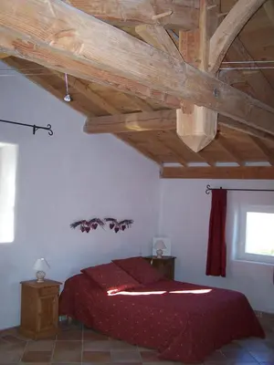 a bedroom with a bed with a wooden ceiling at La Bastide de Ninou maison de vacances Luberon in Viens