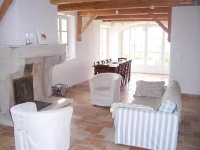 a living room with a fireplace and a table and chairs at La Bastide de Ninou maison de vacances Luberon in Viens