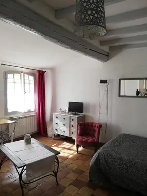 a bedroom with a bed and a table and a chair at Studio ensoleillé, typique centre historique, wifi in Aix-en-Provence