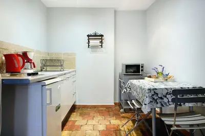 a small kitchen with a table and a stove at Studio ensoleillé, typique centre historique, wifi in Aix-en-Provence