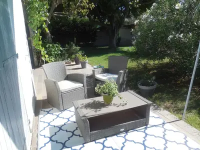 a patio with two chairs and a table with at La maison bleue in LʼIsle-sur-la-Sorgue