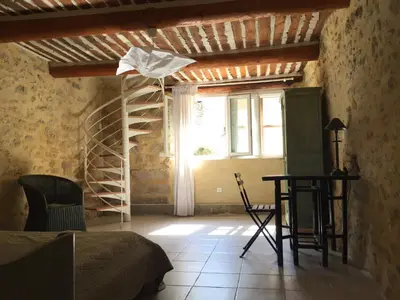 a room with a bed and a window and a staircase at La Magnanerie in Bonnieux