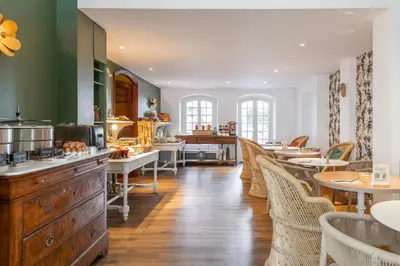 a restaurant with tables and chairs and a kitchen at Hôtel Boutique Cézanne centre Aix-en-Provence in Aix-en-Provence