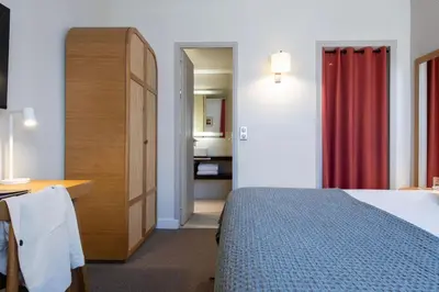 a bedroom with a bed and a desk and a bathroom at Hôtel Boutique Cézanne centre Aix-en-Provence in Aix-en-Provence