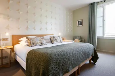 a bedroom with a large bed and a window at Hôtel Boutique Cézanne centre Aix-en-Provence in Aix-en-Provence