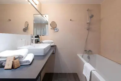 a bathroom with a sink and a bath tub and a mirror at Hôtel Boutique Cézanne centre Aix-en-Provence in Aix-en-Provence