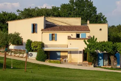 a large white house with trees in the background at Domaine de la Marie dans le Luberon in Peypin-dʼAigues
