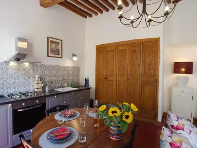 a kitchen with a wooden table and a dining room at Cent Cinq - unique apartments in the heart of Apt in Apt