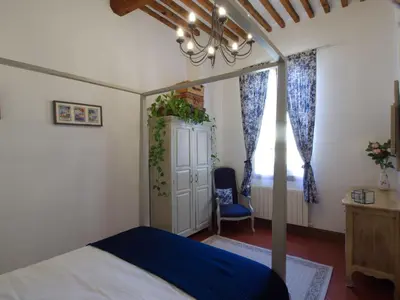 a bedroom with a canopy bed with a blue blanket at Cent Cinq - unique apartments in the heart of Apt in Apt