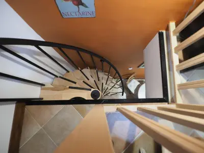 a spiral staircase in a building with a sign on the wall at Cent Cinq - unique apartments in the heart of Apt in Apt