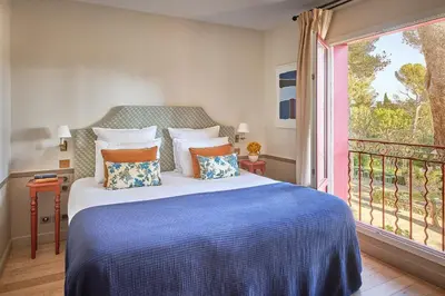 a bedroom with a bed and a large window at Le Pigonnet - Esprit de France in Aix-en-Provence