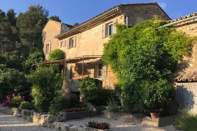an old stone building with flowers in front of it at Château de la Merletade in Cheval-Blanc