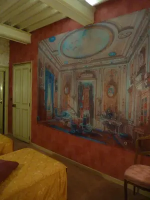 a bedroom with a painting on the wall at Hôtel du Fiacre in Carpentras