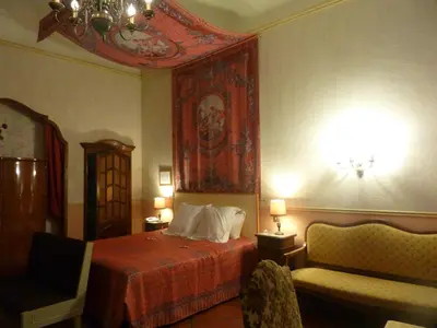 a bedroom with a bed and a painting on the wall at Hôtel du Fiacre in Carpentras