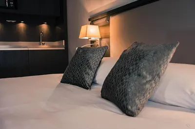 a bedroom with a bed with two pillows on it at Séjours & Affaires Aix-en-Provence Mirabeau in Aix-en-Provence