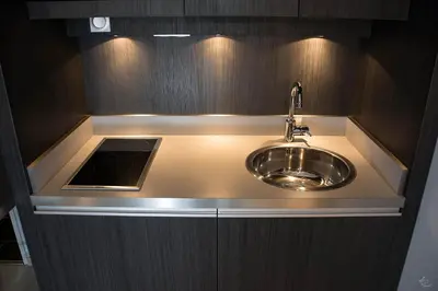 a sink in a kitchen with wooden cabinets at Séjours & Affaires Aix-en-Provence Mirabeau in Aix-en-Provence