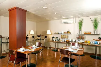 a restaurant with tables and chairs in a room at Séjours & Affaires Aix-en-Provence Mirabeau in Aix-en-Provence