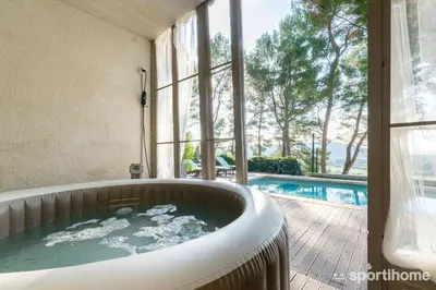 a bath tub in a room with a swimming pool at Le Mas des Roches à Velaux in Velaux