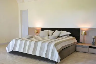 a bedroom with a large bed with striped sheets and pillows at Mas Le 7 in Saint-Andiol
