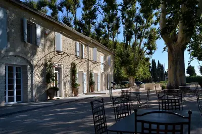 a group of tables and chairs in front of a building at Mas Le 7 in Saint-Andiol