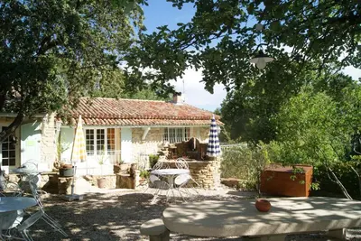 a small stone house with a table in a yard at Le Mas des Chênes in Rognes