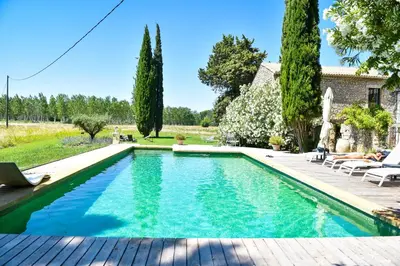 a swimming pool in a yard with a house at Le Mas de la Sorgue in Le Thor