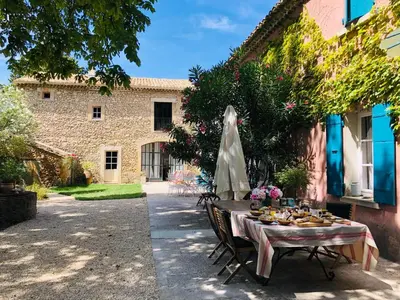 a table with food on it next to a building at Le Mas de la Sorgue in Le Thor