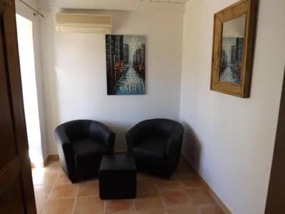 two chairs and a table in a room with a painting at Mas Dansavan Chambres d'hôtes in Oppède