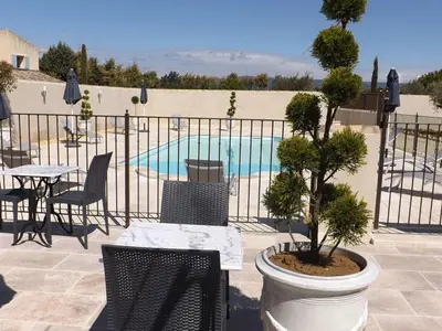 a patio with a table and chairs and a pool at Mas Dansavan Chambres d'hôtes in Oppède