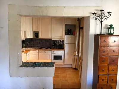 a kitchen with white cabinets and a stove top oven at La Source à Bonnieux en Luberon in Bonnieux