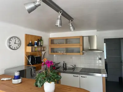a kitchen with a sink and a clock on the wall at T2 de la Bastide Rouge vue exceptionnelle (180°) sur Aix domaine privé T2 indépendant de 37 m2 avec terrasse exposée plein sud Piscine 10 X 5 in Aix-en-Provence