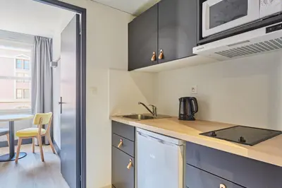 a kitchen with a sink and a counter top at Appart'hôtel Odalys City - Aix en Provence Centre Palais des Congrès in Aix-en-Provence