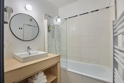 a bathroom with a sink and a shower at Appart'hôtel Odalys City - Aix en Provence Centre Palais des Congrès in Aix-en-Provence