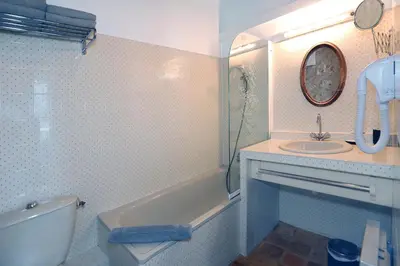 a bathroom with a sink and a tub and a toilet at Le Cheval Blanc in La Bastide-des-Jourdans