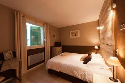a bedroom with a bed and a window at Le Devem De Mirapier in Cornillon-Confoux