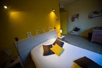 a bedroom with a large white bed with yellow walls at Le Devem De Mirapier in Cornillon-Confoux