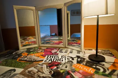 a bed with two mirrors and a lamp on a table at Le Devem De Mirapier in Cornillon-Confoux