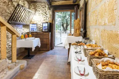 a restaurant with two tables with plates of food at Best Western Domaine de Roquerousse in Salon-de-Provence