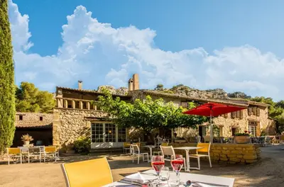 a patio with tables and chairs and a building at Best Western Domaine de Roquerousse in Salon-de-Provence