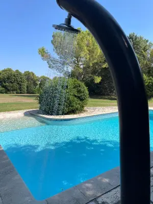 a pool with a water fountain in a park at Gîte et maison de vacances Campagne Valérie in Aix-en-Provence
