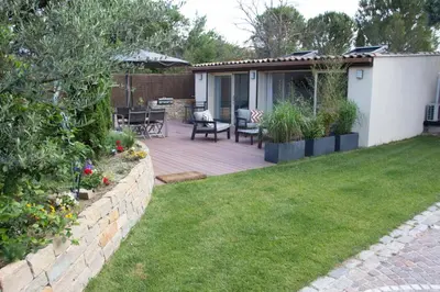 a backyard with a wooden deck with a table and chairs at Gîte et maison de vacances Campagne Valérie in Aix-en-Provence