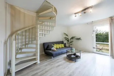 a living room with a couch and a spiral staircase at Garden & City Aix En Provence - Puyricard in Aix-en-Provence