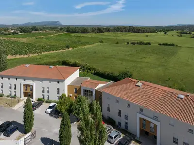 an aerial view of a building and a field at Garden & City Aix En Provence - Puyricard in Aix-en-Provence